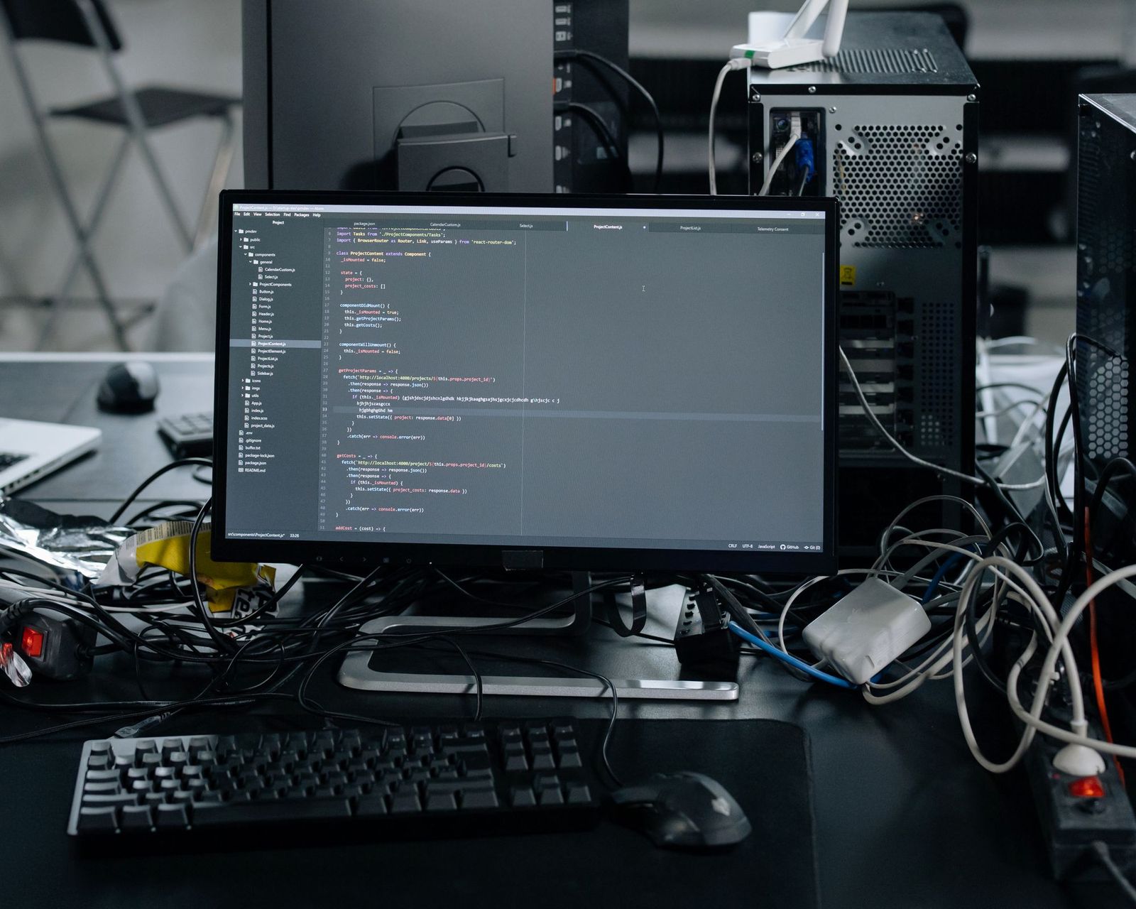 An engineering workstation with a monitor showing source code, keyboard and cabling